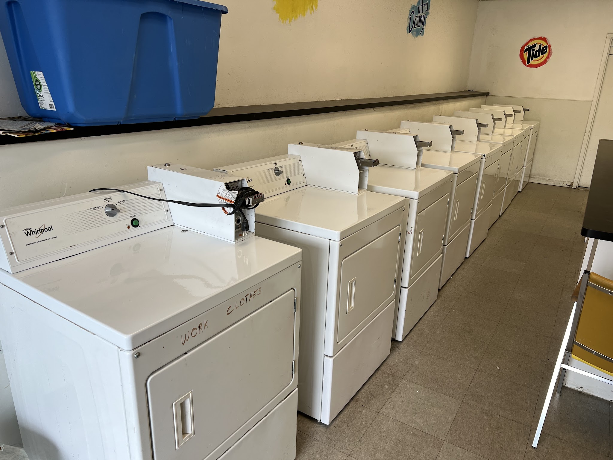 Row of self-serve washers and dryers in the laundry room